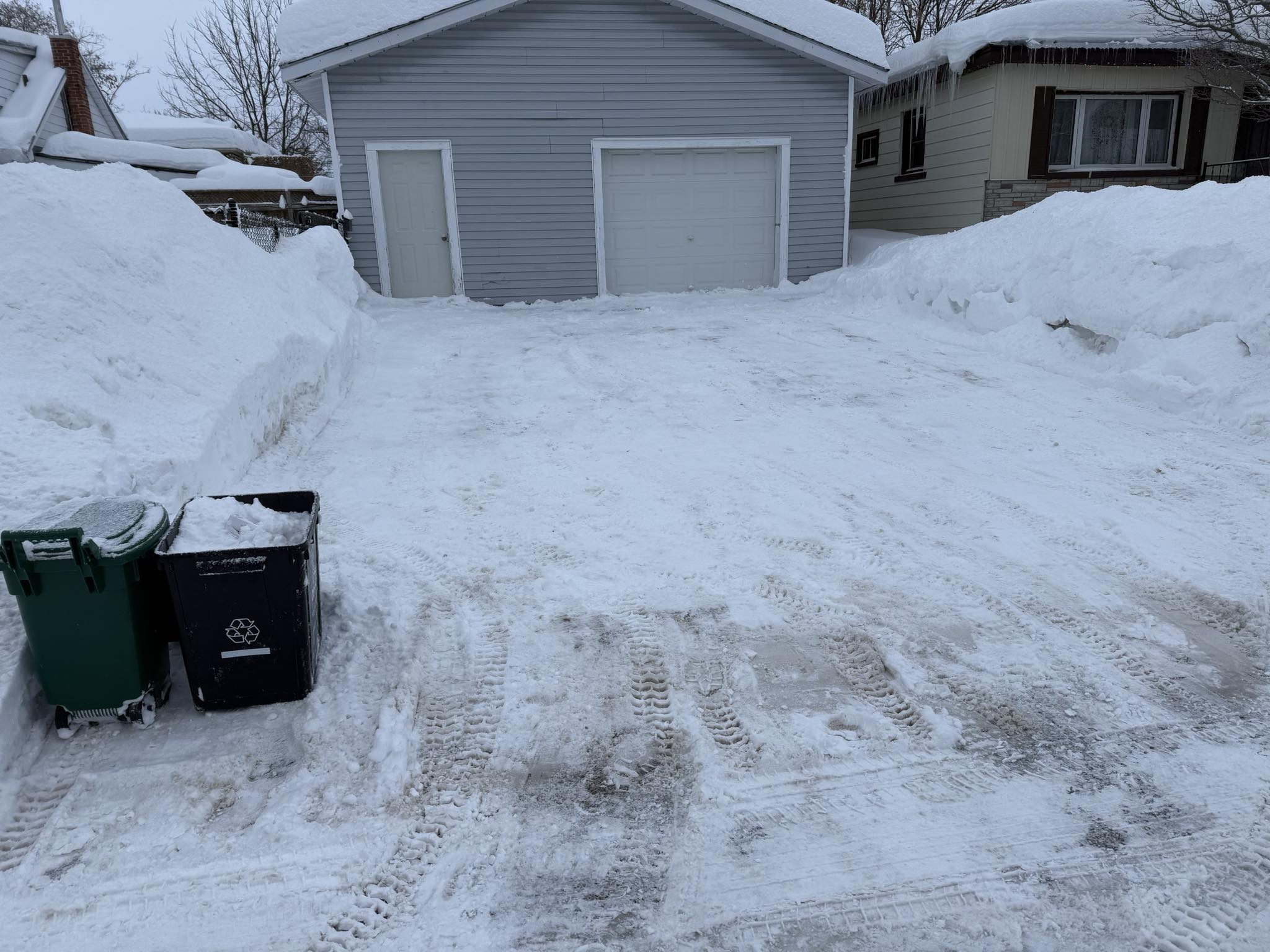 Residential driveway cleared down to bare pavement after a winter snowfall in Orillia